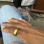Gen 3 Gold Health Tracking Ring — gold ring worn on a hand resting on blue denim