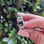 Gen 3 Silver Fitness Ring — silver ring held between fingers in front of green leaves