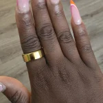 Gen 3 Gold Health Tracking Ring — gold ring worn on a hand with pink and orange nails