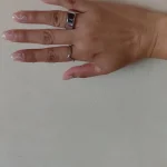 Gen 3 Silver Health Tracking Ring — silver ring worn on an outstretched hand against a light wall